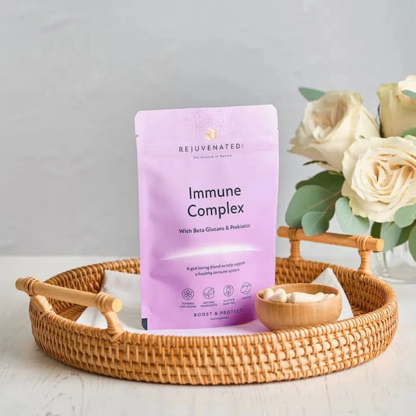 Rejuvenated Immune Complex packet on a woven tray and cup of capsules