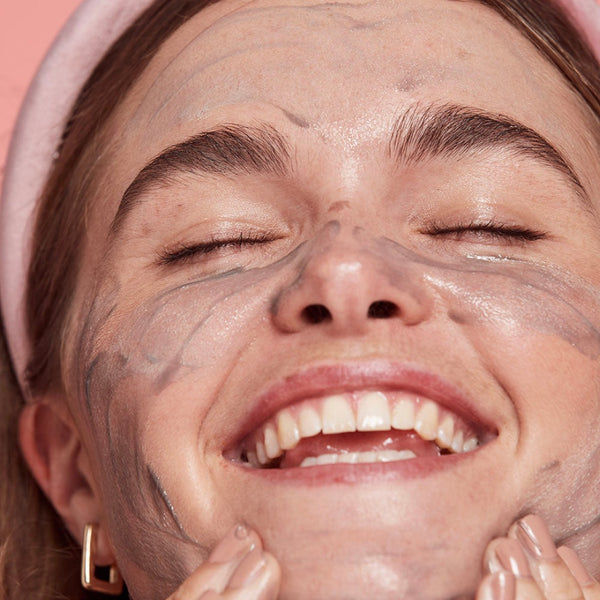 a close up of a women applying cleanser to her face