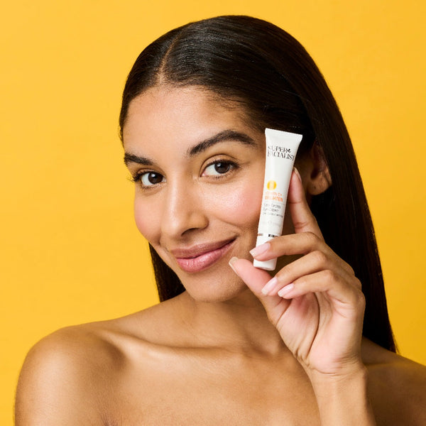 Model headshot close up holding vitamin c eye cream